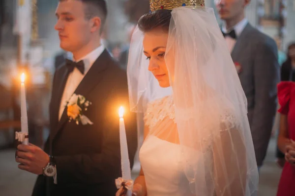 Крупним планом горизонтальний портрет молодят, що тримають свічки під час церемонії одруження . — стокове фото