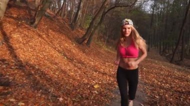 Sonbahar park boyunca koşu çekici sarışın kadın görünümünü yakın çekim.