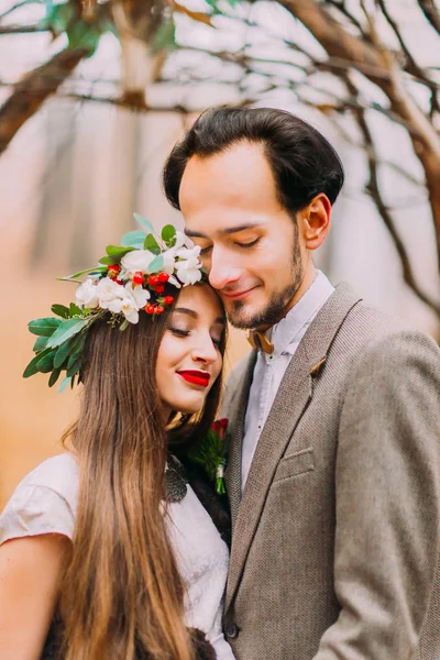 Lyckliga bruden och brudgummen mjukt kramas i höst skogen närbild — Stockfoto