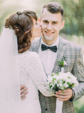 Gelin Damat Düğün buket ile yanak içinde öpüşme yakın çekim portresi.