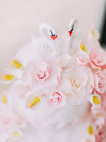 Los cisnes decoran el pastel de boda blanco con flores rosadas . —  Fotos de Stock