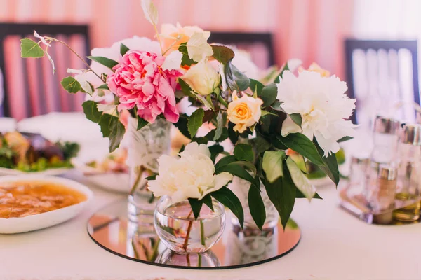 Belo buquê de flores de rosas coloridas e peônias nos mini-vasos no conjunto de mesa de casamento . — Fotografia de Stock