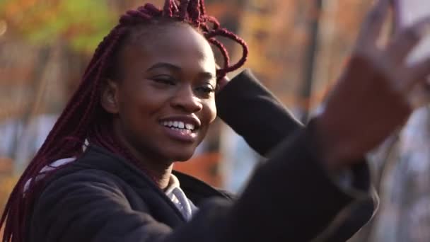 Una afro-americana sonriente se está tomando selfies. El retrato de cerca . — Vídeos de Stock