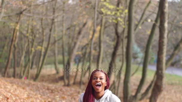 Horizontální pohled šťastné afro-american holka hodí zažloutlé listy ve vzduchu. — Stock video