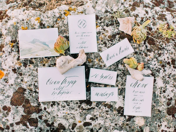 A foto de close-up dos diferentes cartões postais colocados na pedra e decorados com ervas diferentes . — Fotografia de Stock