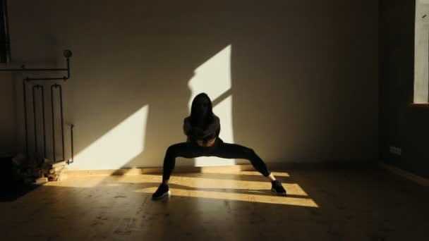 A menina bonita está fazendo lunges lado no quarto escuro . — Vídeo de Stock