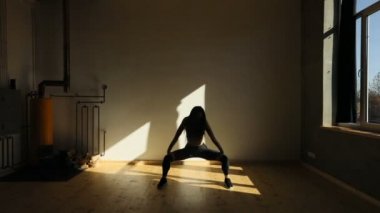 Ayakları üzerinde duran ve pelvis yukarı ve aşağı fitness stüdyo hareketli çekici atletik kadın os silüeti.
