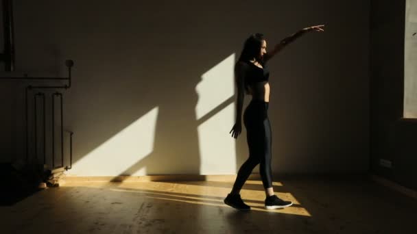 Die attraktive Sportlerin tanzt im Studio herum. sie bewegt das Becken. — Stockvideo