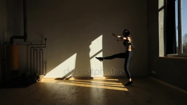 La vista de la mujer haciendo ejercicio y saltando en el estudio mal iluminado . — Vídeo de stock