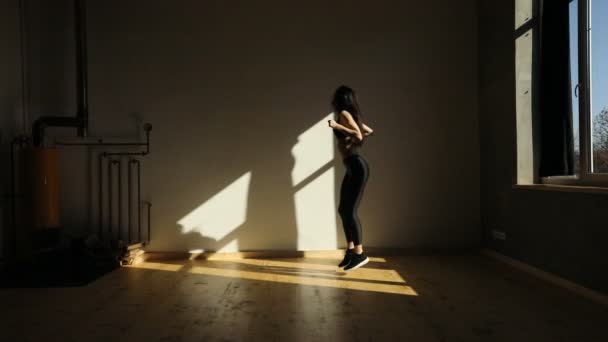 Horizontal view of the athletic woman jumping in place in the fitness studio. — Stock Video