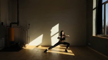 Genç sportwoman yana lunges kötü ışıklı Studio yapıyor.