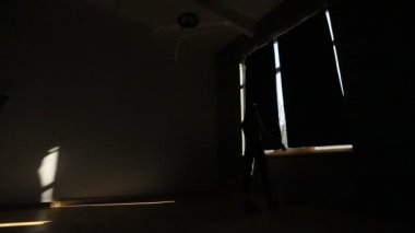 Çekici sportwoman pencereye geliyor, karanlık perdeleri çekerek ve eğitim önce ısınma.