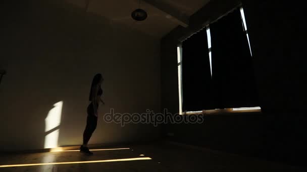 La vue horizontale de la femme sportive levant sur les pieds et faisant des fentes dans le studio sombre . — Video