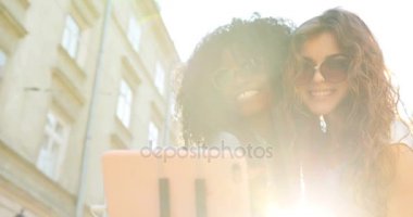 İki sevimli gülümseyen kız selfie yaparken hava öpücük gönderme yakın çekim portre. Onlardan biri Afro-Amerikan.