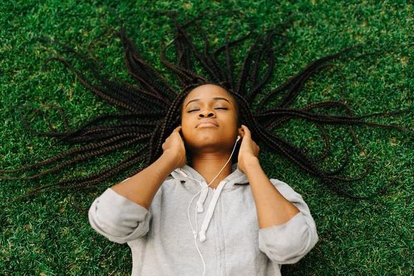 Acima vista da menina pacífica apreciando a música nos fones de ouvido. O adolescente é afro-americano . — Fotografia de Stock