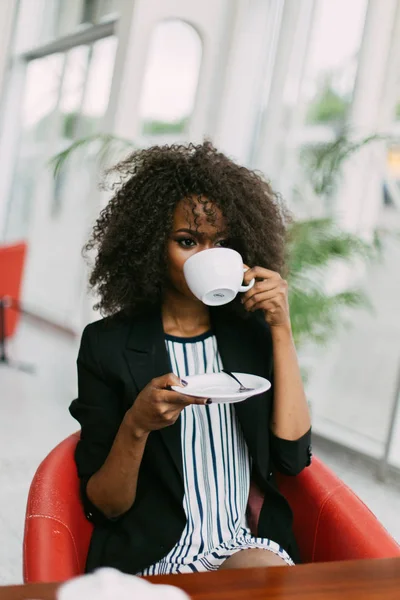 Напівдовгий портрет красивої афроамериканки, яка п'є чай. Розташування кафе . — стокове фото