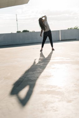 Sokakta dans ederken onu pigtails dokunan genç Afro-Amerikan kadın tam uzunlukta görünümünü.