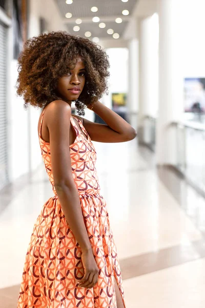 Glückliche Afrikanerin in wunderschönem Kleid in einem Einkaufszentrum. — Stockfoto