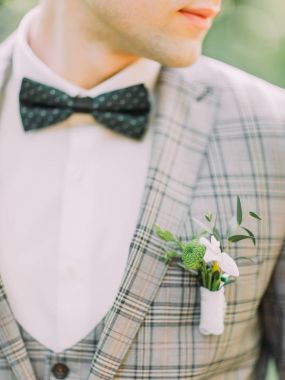 Damadın ceketindeki küçük yaka çiçeğinin yakın çekimi..