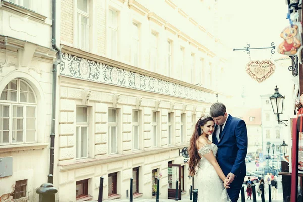 Uśmiechający się nowożeńcy są przytulanie a spędzanie czasu w starożytnej ulicy w Pradze. — Zdjęcie stockowe