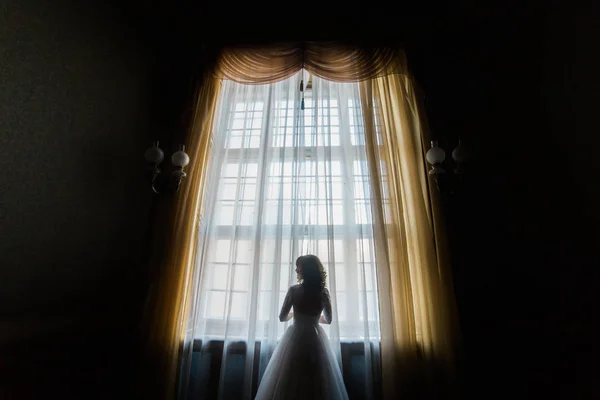 A visão traseira da noiva em pé perto da janela do castelo . — Fotografia de Stock