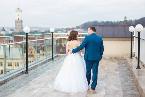 Vista horizontal da caminhada dos recém-casados abraçando feliz ao longo do telhado . — Fotografia de Stock