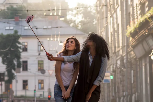 Δύο φίλοι που ποζάρουν για την κάμερα λήψης selfie. Ευτυχισμένος νεαρές γυναίκες. Μία γυναίκα είναι μαύρο. — Φωτογραφία Αρχείου