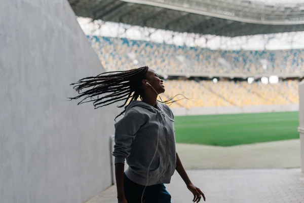 O adolescente afro-americano alegre está balançando a cabeça no fundo do estádio . — Fotografia de Stock