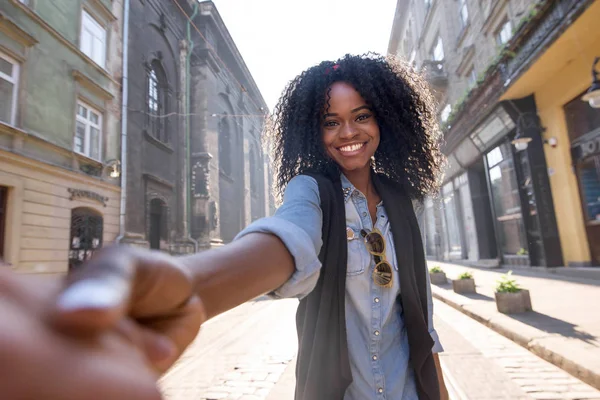 Mutlu siyah kız bir ele sahip ve kamera için poz. Kız aroung şehir güneşli bir günde yürüyüş. — Stok fotoğraf
