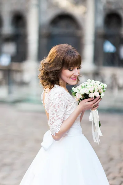 Nahaufnahme Porträt der Braut, die den Brautstrauß auf der Straße riecht. — Stockfoto