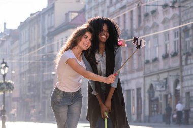 Mutlu atrractive kızlar güzel mimari ile şehrin merkezinde selfie yapma. Blck bir kızdır.