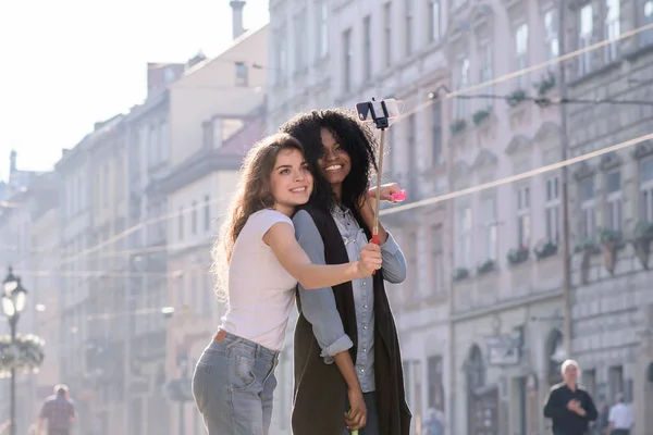 Çekici siyah kız arkadaşı ile selfie yapma. Kızlar güzel mimari ile şehrin merkezinde daimi. — Stok fotoğraf