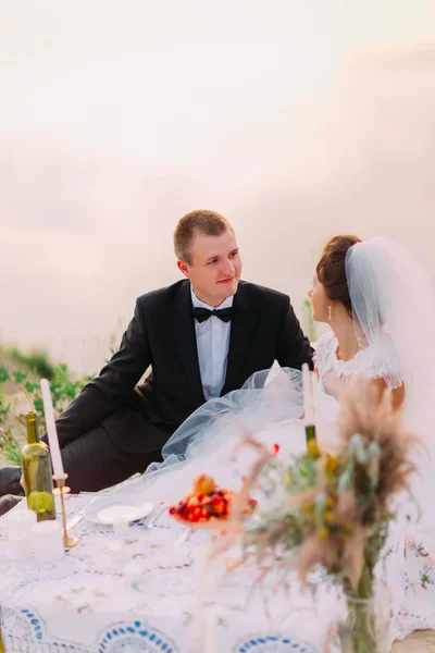 De jonggehuwde paar is genieten van de bruiloft picknick in de buurt van de zee. — Stockfoto