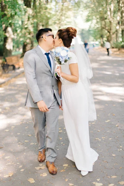 Beso tierno de pareja de boda con estilo besándose en el camino — Foto de Stock