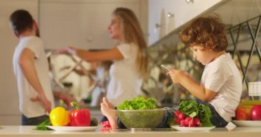 Cep telefonu elinde küçük bir çocukla mutfak mobilya önde oturuyor iken savunarak anne arka plan, annesi babası tokat.