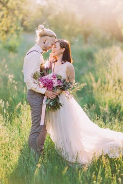 Yakın çekim portre pf güneşli parkta yeni evliler. Adam gelinini kafe okşuyor.