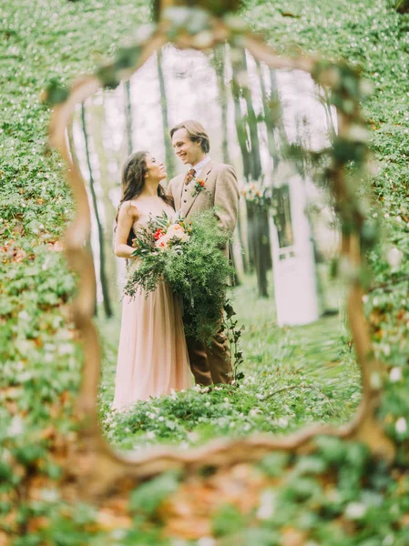 Os recém-casados na roupa vintage em plena alta olhando para o outro e seu reflexo no espelho. A foto de close-up na floresta . — Fotografia de Stock