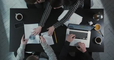 İşadamları not defterinde yazarken grafik ve dizüstü kullanarak iş sorunları çözme. Yukarıdaki kompozisyon.