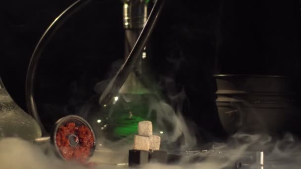 Vue rapprochée horizontale de la composition composée de matériel de fumée, braises et changement de couleurs narguilé enveloppé par l'énorme nuage épais de fumée .