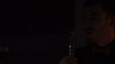 Adam, karanlık odada kömür parçası esiyor. Kıvılcımlar her yerde düşüyor.