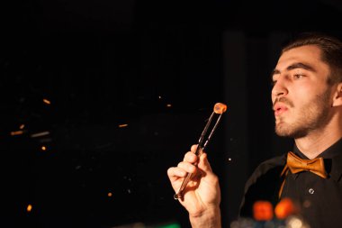 Yakın çekim af nargile kor tutarak ve üzerinde üfleme bir nargile adamı vurdum..