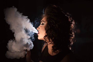 Nargile duman kadın kıvırcık saçlı ve kırmızı dudaklar exhaling portresi.