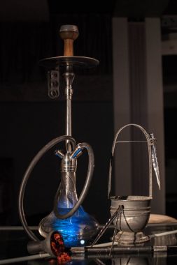 Mavi nargile birlikte WIT karanlık bir arka plan bir barda aksesuarları yerleştirilen.