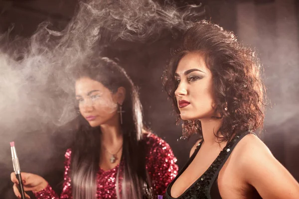 Closeup shot of two young women with hookah pipes in their hands. — Stock Photo, Image