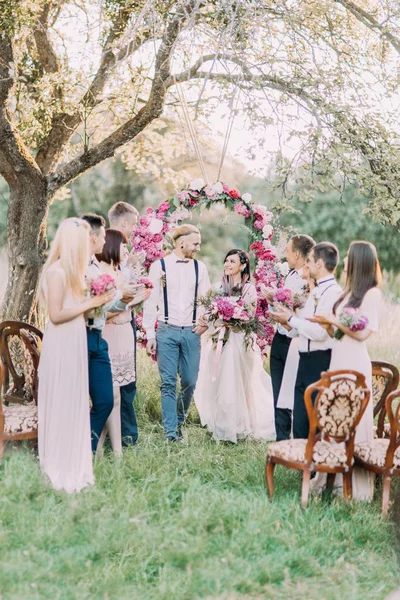 La ceremonia de la boda en el soleado parque. Los recién casados están caminando mientras sus invitados aplauden . — Foto de Stock