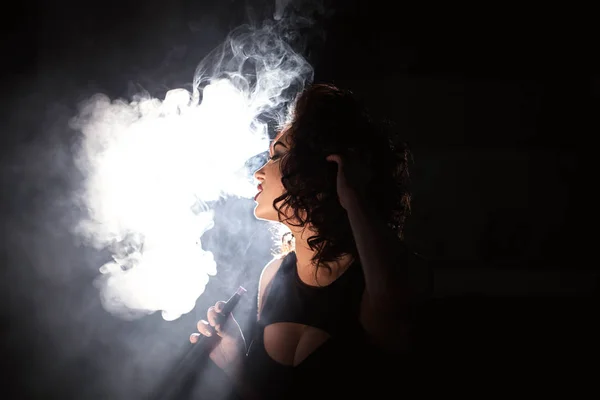 Сексуальная молодая женщина выдыхает облако дыма. Женщина курит кальян . — стоковое фото