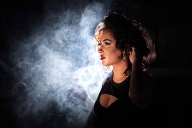 Derin yaka elbise giyen bir nargile içinde bir kadın yakın çekim shot duman.