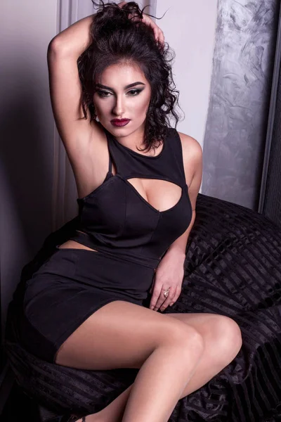 Atrractive esmer kadın kamera için poz. Kadın kıvırcık saçlı ve kırmızı dudaklar.