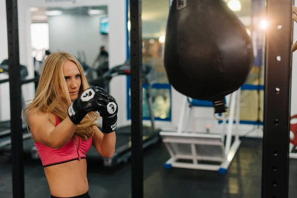 Mladá žena školení na boxovací pytel. koncept o sportu, fitness, bojových umění a lidé — Stock fotografie
