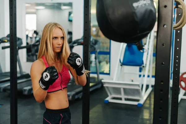 Szőke sportoló lány boksz a lyukasztó zsák. koncepció, a sport, fitness, és az emberek — Stock Fotó